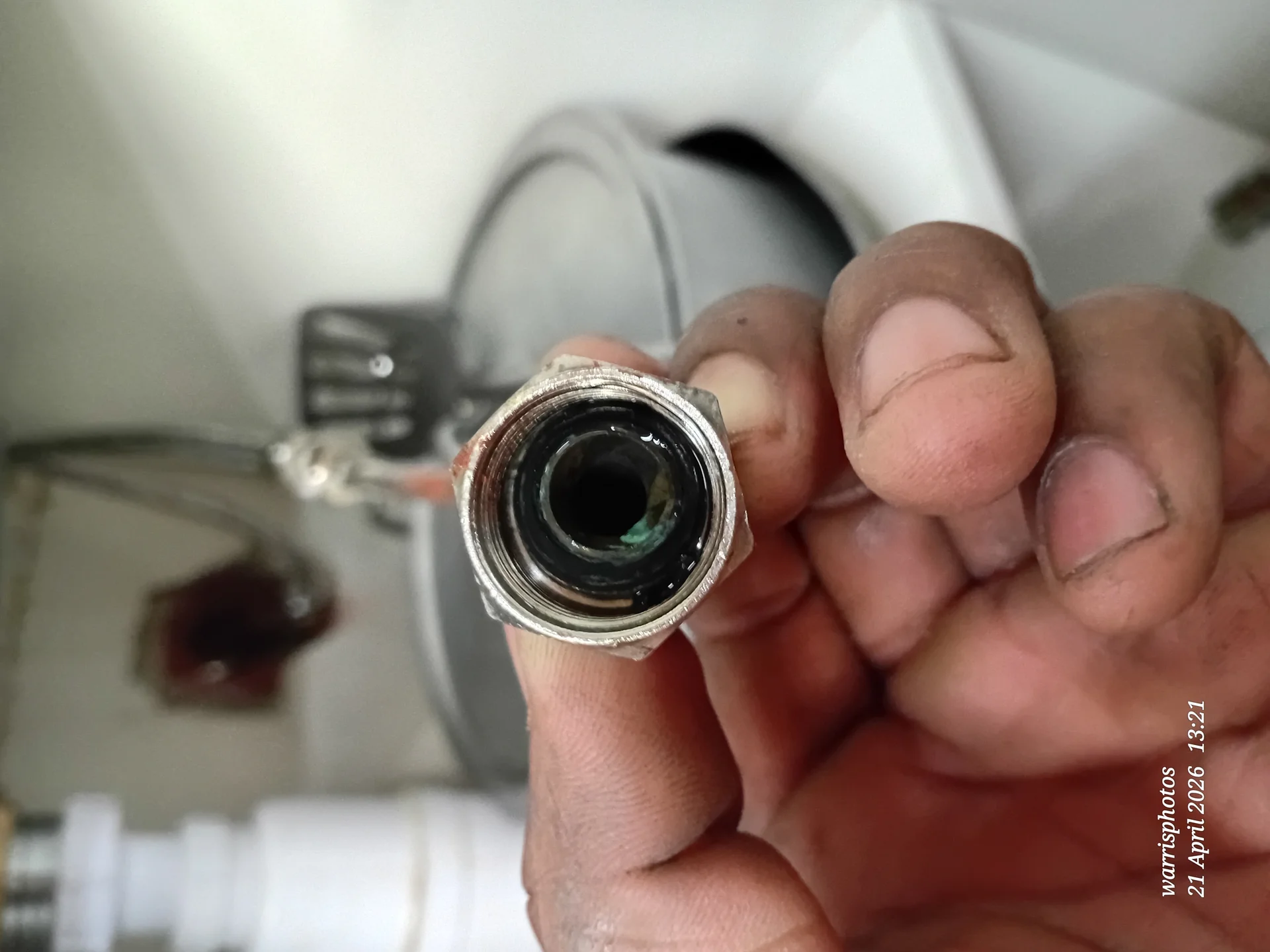 Professional plumber fixing pipes in a modern kitchen